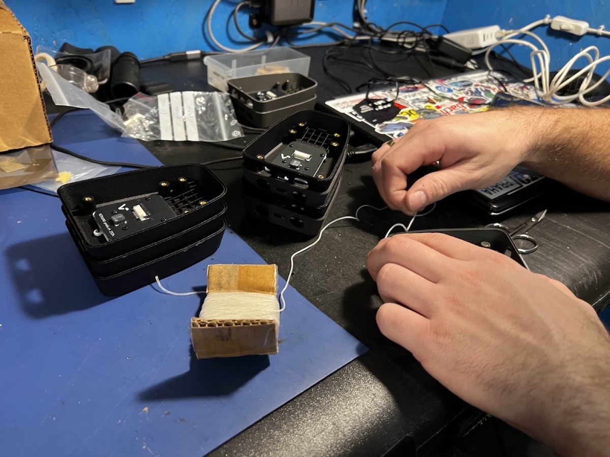 Hands wiring up VetkuroGPS units on the workbench
